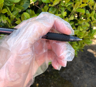 hand in a plastic glove holding a pen | Hugh James hand in a plastic glove holding a pen | Hugh James