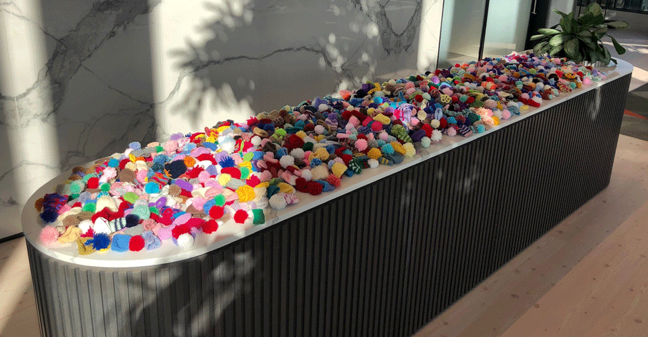 Full table display of over 1000 of the Big Knit hats knitted by Hugh James colleagues