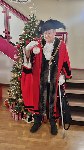Bristol’s Right Honourable Lord Mayor, Chancellor Paul Goggin placing the final ornament for Decorate for December at Ronald McDonald House Bristol