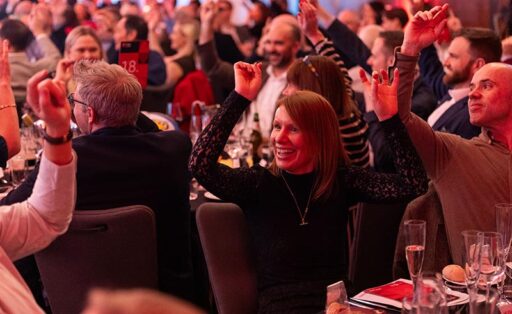 Crowd smiling with hands in the air at the Hugh James Rugby Lunch 2026